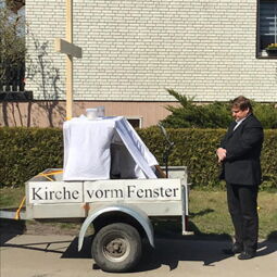 Kirche vorm Fenster mit Pfarrer Haake