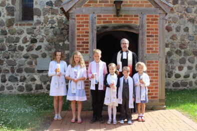 Täuflinge mit Stola und Taufkerzen